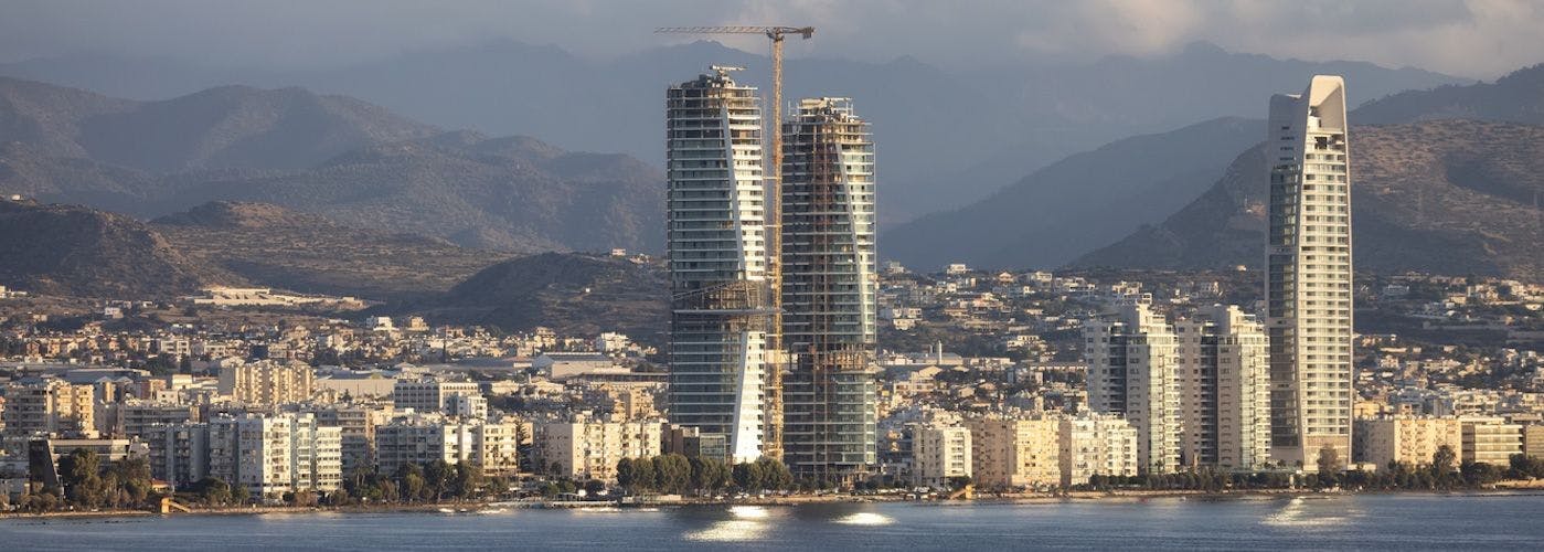 Limassol skyline with emerging skyscrapers against a mountainous backdrop, reflecting the growth of Cyprus VPS Hosting.