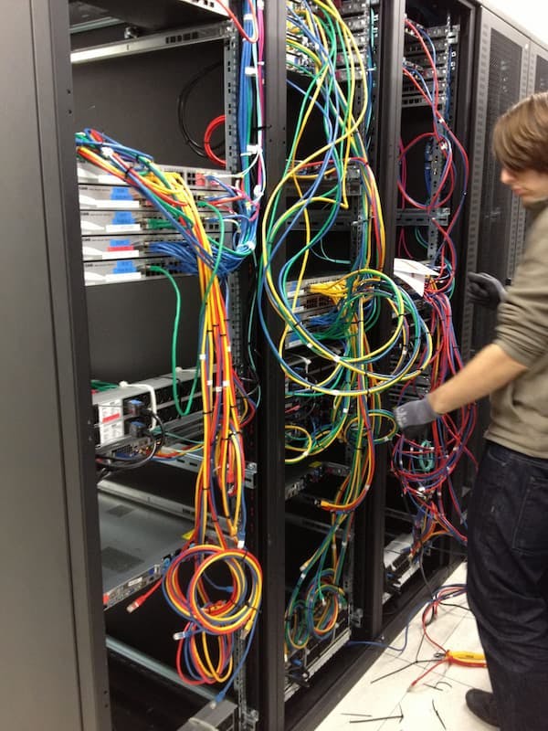 Technician installing VPS hosting servers with an array of colorful cables in Vienna